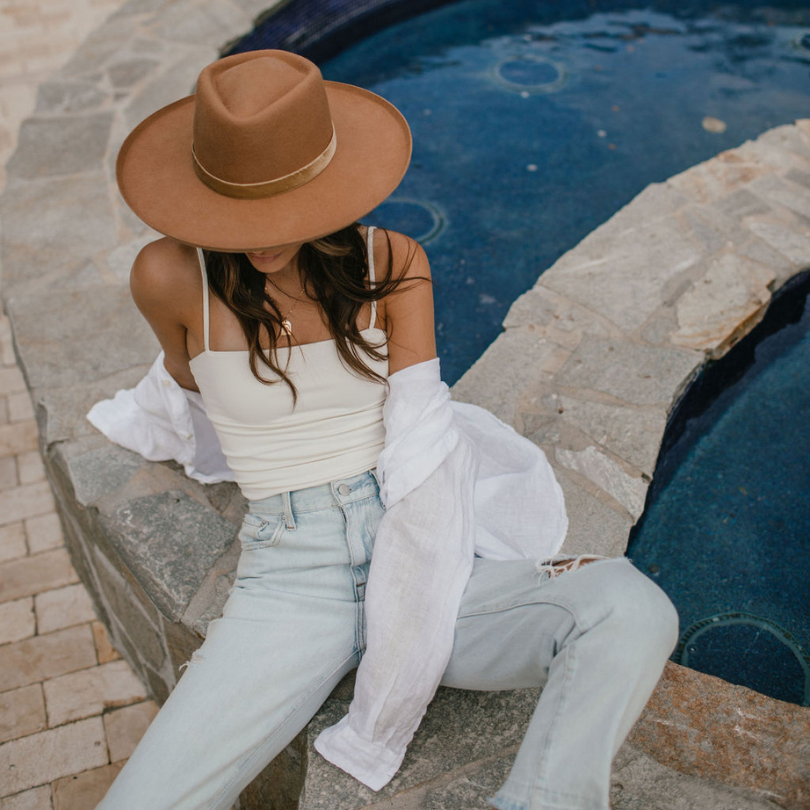 Roux Collective Boutique model wearing white top and light wash blue jeans.